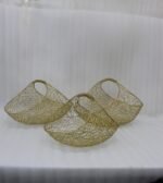 Set of three gold mesh wire decorative metal baskets displayed on a marble countertop with minimalist décor