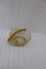 Gold woven wire decorative basket with a natural wooden handle sitting on a wooden tabletop