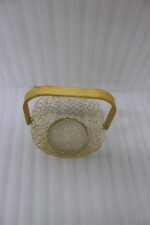 Gold woven wire decorative basket with a natural wooden handle sitting on a wooden tabletop