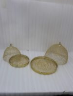 Two gold decorative metal wire mesh dome cloche covers sitting on a wooden table.