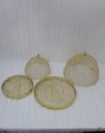 Two gold decorative metal wire mesh dome cloche covers sitting on a wooden table.