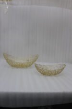 Set of two gold wire decorative metal baskets sitting on a wooden kitchen island counter