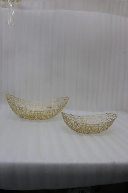 Set of two gold wire decorative metal baskets sitting on a wooden kitchen island counter