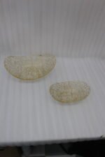 Set of two gold wire decorative metal baskets sitting on a wooden kitchen island counter