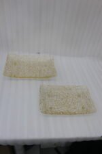 Pair of decorative gold wire mesh baskets with footed base displayed on a white kitchen countertop
