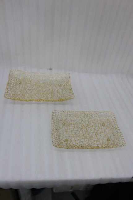Pair of decorative gold wire mesh baskets with footed base displayed on a white kitchen countertop