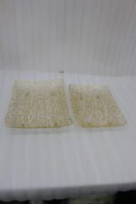 Pair of decorative gold wire mesh baskets with footed base displayed on a white kitchen countertop
