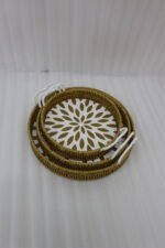 Set of 3 round handwoven rattan serving trays with white base patterns and handles resting on a wooden table