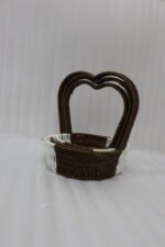 Nested set of three brown and white handwoven rattan trays featuring tall heart-shaped handles on a wooden table