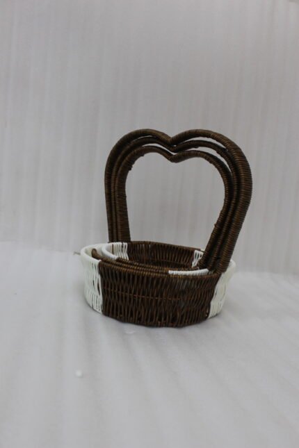 Nested set of three brown and white handwoven rattan trays featuring tall heart-shaped handles on a wooden table