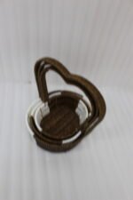 Nested set of three brown and white handwoven rattan trays featuring tall heart-shaped handles on a wooden table