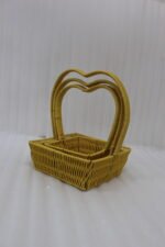 Set of 3 yellow woven rattan nesting trays with high arched handles stacked on a wooden coffee table.