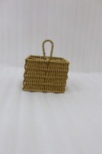 Two handwoven rattan spoon holders with four divided compartments and loop handles sitting on a marble table.