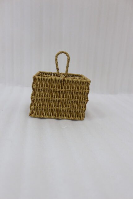 Two handwoven rattan spoon holders with four divided compartments and loop handles sitting on a marble table.