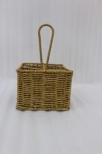 Two handwoven rattan spoon holders with four divided compartments and loop handles sitting on a marble table.