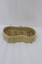 Handwoven apple-shaped natural rattan fruit dish sitting on a wooden coffee table in a modern living room setting.