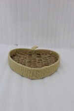 Apple-shaped handwoven rattan fruit tray sitting on a light wooden table