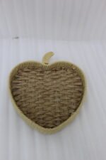 Apple-shaped handwoven rattan fruit tray sitting on a light wooden table