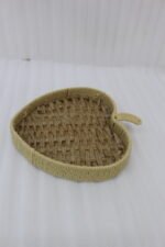 Apple-shaped handwoven rattan fruit tray sitting on a light wooden table