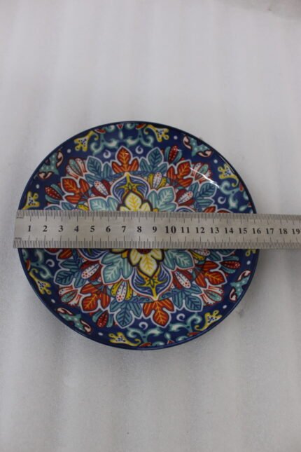 Decorative ceramic bowls with traditional Marrakech hand-painted designs on a rustic wooden dining table.