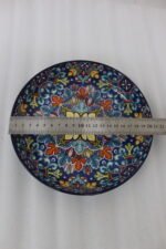 Decorative ceramic bowls with traditional Marrakech hand-painted designs on a rustic wooden dining table.