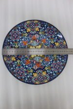 Two vibrant blue, yellow, and red decorative Marrakech ceramic plates displaying intricate mosaic patterns on a white marble surface in 8-inch and 10-inch sizes.