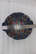 Three hand-painted decorative Marrakech ceramic bowls with intricate bohemian patterns and handles arranged on a dining table runner.