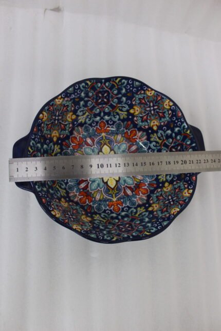 Three hand-painted decorative Marrakech ceramic bowls with intricate bohemian patterns and handles arranged on a dining table runner.