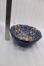 Three hand-painted decorative Marrakech ceramic bowls with intricate bohemian patterns and handles arranged on a dining table runner.