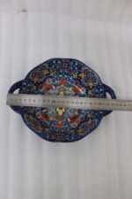 Three hand-painted decorative Marrakech ceramic bowls with intricate bohemian patterns and handles arranged on a dining table runner.
