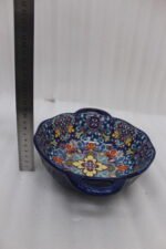 Three hand-painted decorative Marrakech ceramic bowls with intricate bohemian patterns and handles arranged on a dining table runner.
