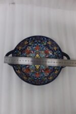 Three hand-painted decorative Marrakech ceramic bowls with intricate bohemian patterns and handles arranged on a dining table runner.