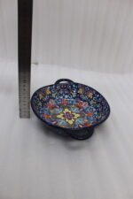 Three hand-painted decorative Marrakech ceramic bowls with intricate bohemian patterns and handles arranged on a dining table runner.