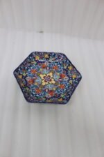 Decorative Marrakesh ceramic serving dish with colorful Moroccan mosaic pattern resting on a wooden dining table.