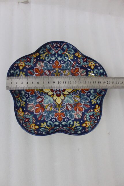 Decorative Marrakesh serving dish with a colorful ceramic mandala pattern and wavy edges on a wooden table