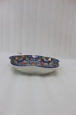 Decorative Marrakesh serving dish with a colorful ceramic mandala pattern and wavy edges on a wooden table