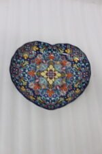 Decorative Marrakesh ceramic serving dish with colorful bohemian mandala pattern resting on a white marble kitchen countertop