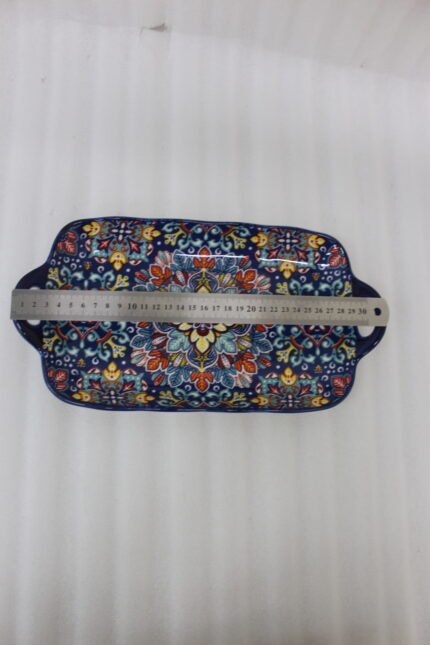 Intricate vibrant blue and yellow Marrakech ceramic serving dish tray with built-in handles on a stone countertop
