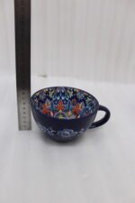 Royal blue handcrafted Marrakech ceramic mug with intricate floral interior pattern sitting on a kitchen counter