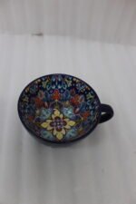 Royal blue handcrafted Marrakech ceramic mug with intricate floral interior pattern sitting on a kitchen counter