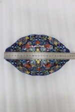 9.5-inch decorative Marrakech oval ceramic serving bowl with intricate blue, orange, and yellow hand-painted floral patterns resting on a marble countertop