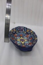 9.5-inch decorative Marrakech oval ceramic serving bowl with intricate blue, orange, and yellow hand-painted floral patterns resting on a marble countertop