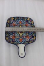 Square 6.5-inch Marrakech ceramic serving dish with colorful mosaic mandala patterns and an integrated handle on a wooden table.