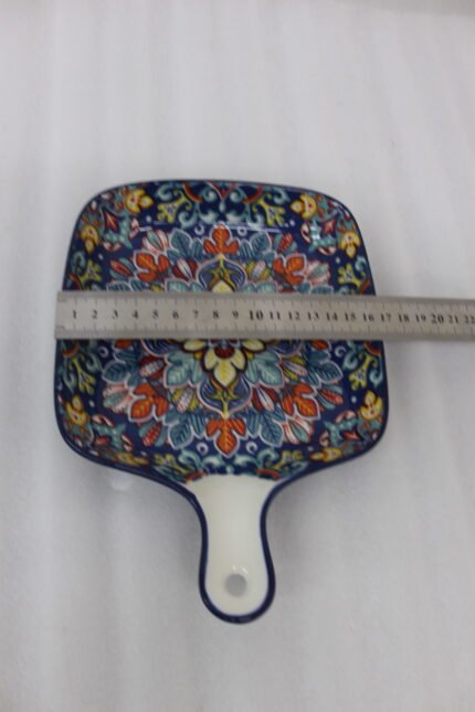 Square 6.5-inch Marrakech ceramic serving dish with colorful mosaic mandala patterns and an integrated handle on a wooden table.