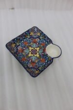 Square hand-painted Moroccan ceramic serving dish with colorful Marrakech floral pattern and built-in dip bowl on a wooden table.