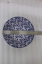 Pair of decorative blue and white Marrakesh ceramic floral bowls in 6-inch and 8-inch sizes sitting on a marble kitchen countertop.