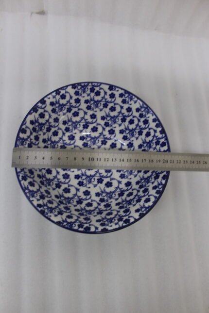 Pair of decorative blue and white Marrakesh ceramic floral bowls in 6-inch and 8-inch sizes sitting on a marble kitchen countertop.