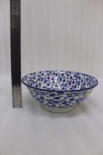 Pair of decorative blue and white Marrakesh ceramic floral bowls in 6-inch and 8-inch sizes sitting on a marble kitchen countertop.