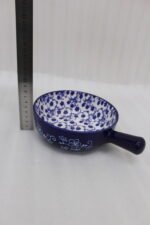 Decorative 6-inch blue and white floral ceramic Marakesh serving dish with single side handle on a wooden kitchen countertop.