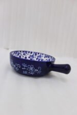 Decorative 6-inch blue and white floral ceramic Marakesh serving dish with single side handle on a wooden kitchen countertop.